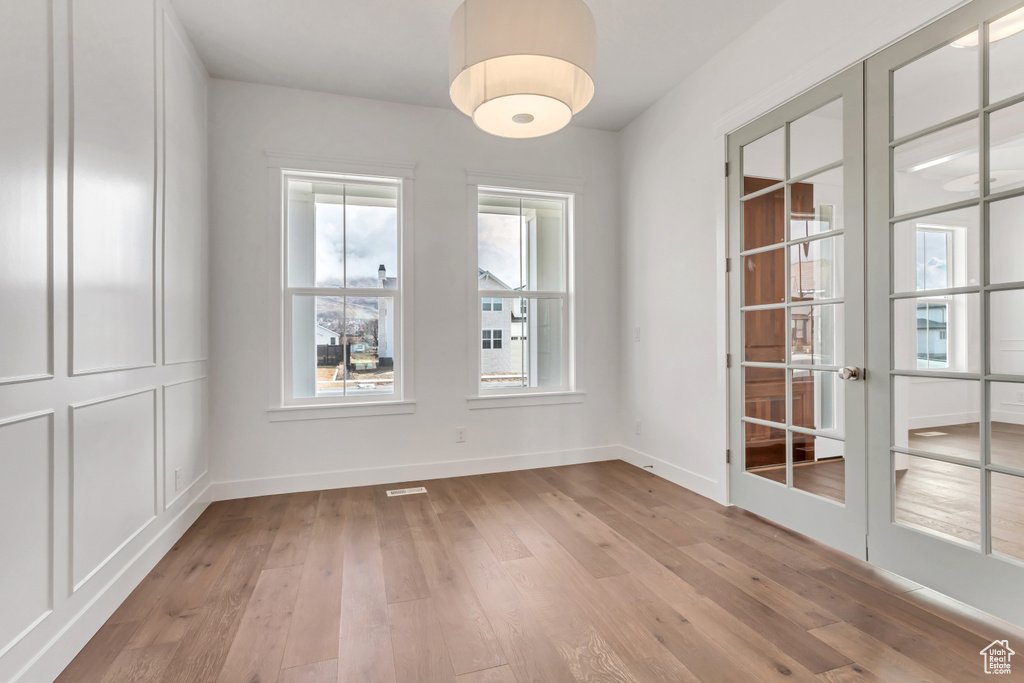 Empty room featuring french doors and light hardwood / wood-style floors