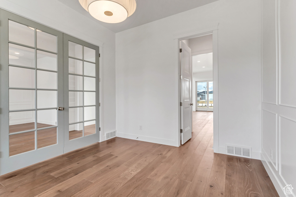 Empty room featuring light hardwood / wood-style floors and french doors