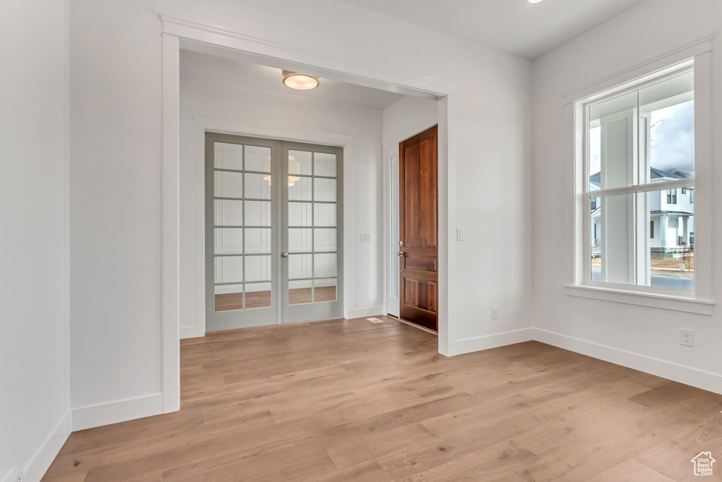 Unfurnished room featuring light hardwood / wood-style flooring and french doors