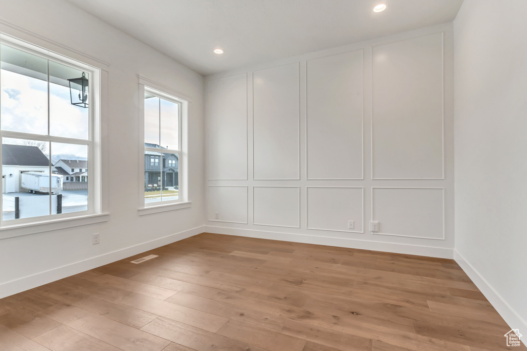 Empty room with light hardwood / wood-style flooring and plenty of natural light