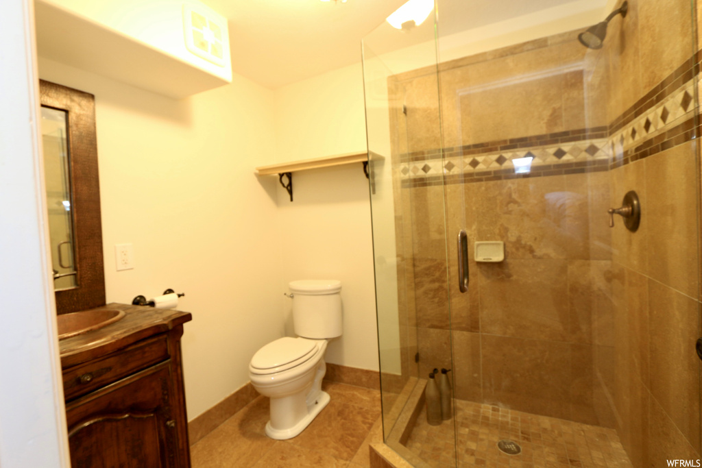 Bathroom with an enclosed shower, large vanity, mirror, and light tile floors