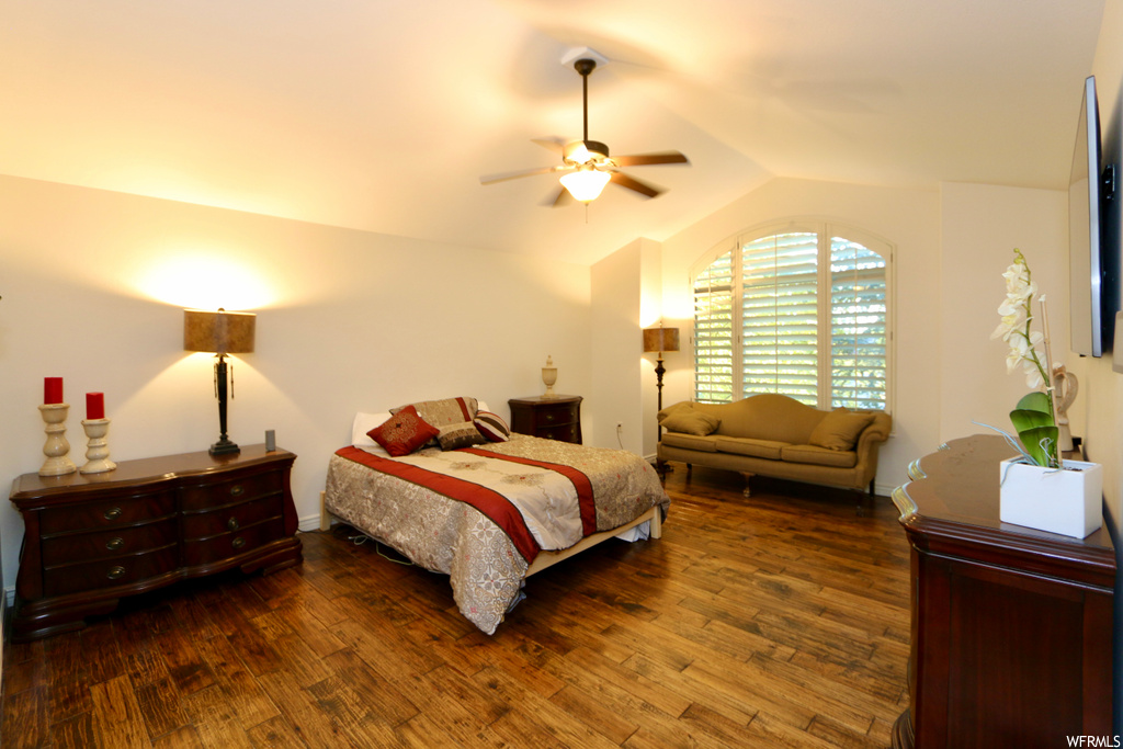 Bedroom with dark hardwood floors and vaulted ceiling
