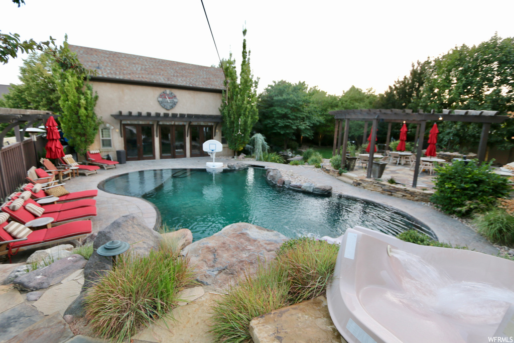 View of swimming pool with a patio and a pergola