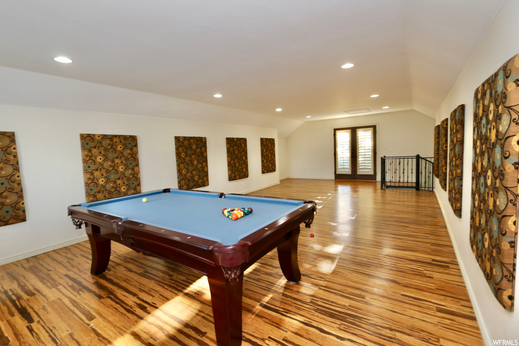 Game room featuring vaulted ceiling and light hardwood flooring