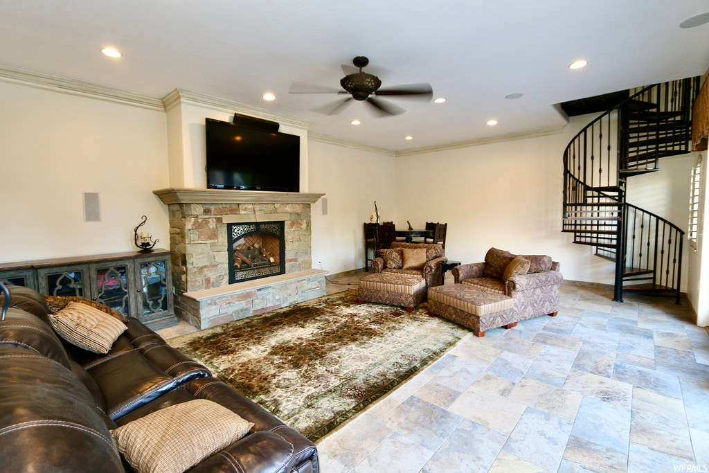Tiled living room featuring crown molding, a fireplace, and ceiling fan