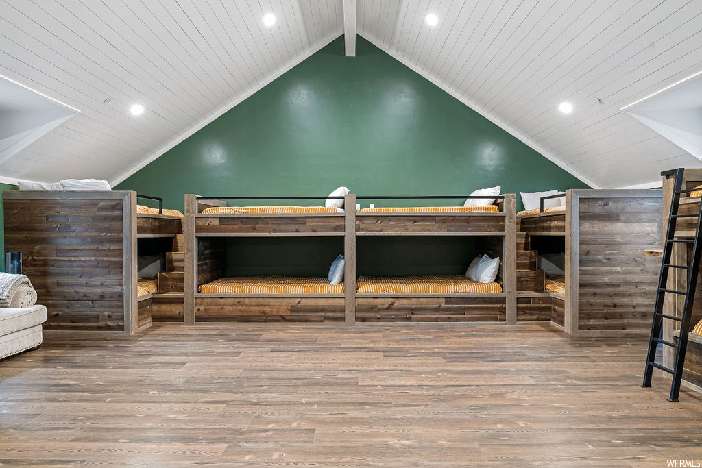 Hardwood floored bedroom featuring wood ceiling and lofted ceiling