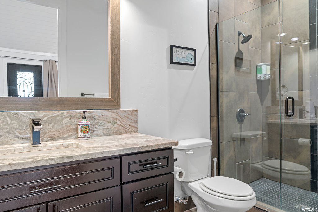Bathroom with oversized vanity, mirror, and a shower with door