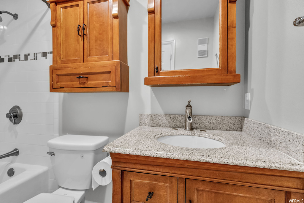 Full bathroom with vanity with extensive cabinet space, tiled shower / bath combo, and mirror