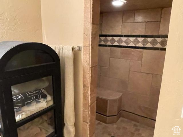 Bathroom with tiled shower and tile floors