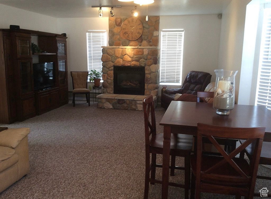 Dining area with carpet and a stone fireplace