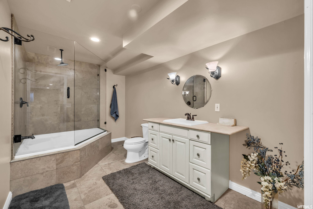Full bathroom featuring bath / shower combo with glass door, vanity, mirror, and light tile flooring