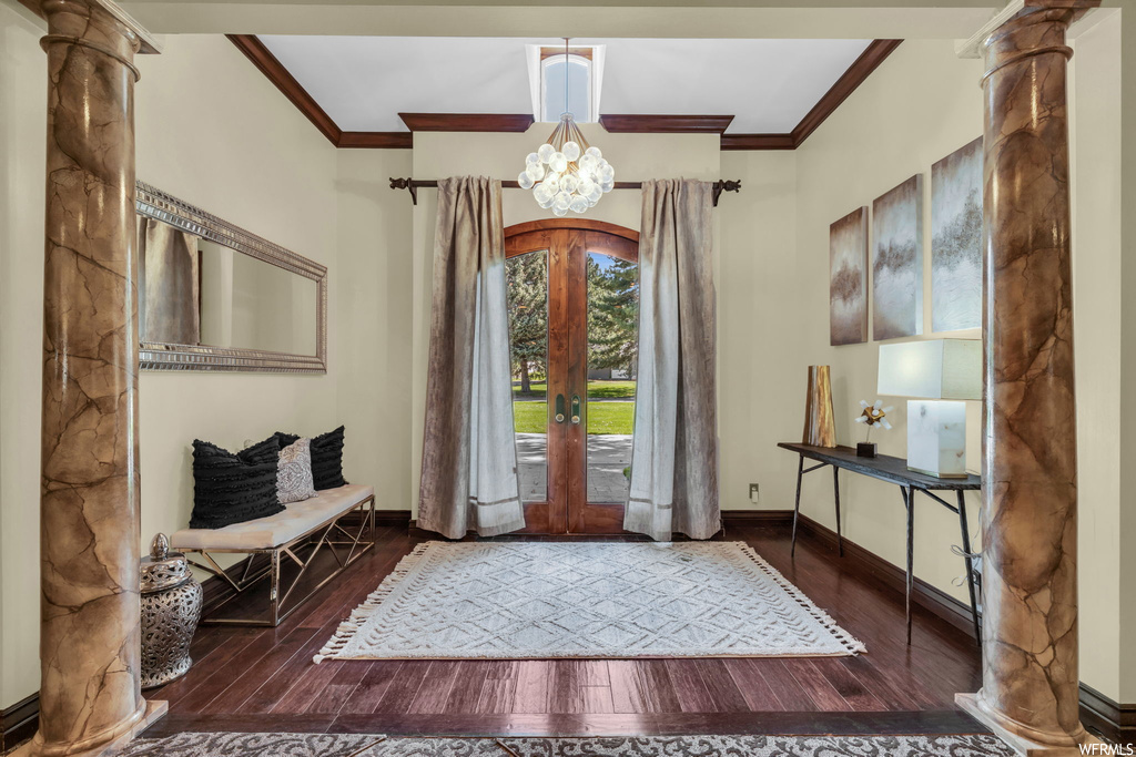 Wood floored foyer featuring crown molding