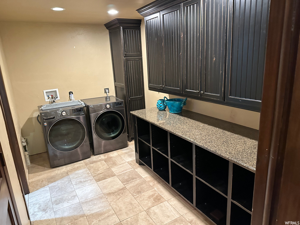 Laundry area featuring washer and clothes dryer and light tile floors
