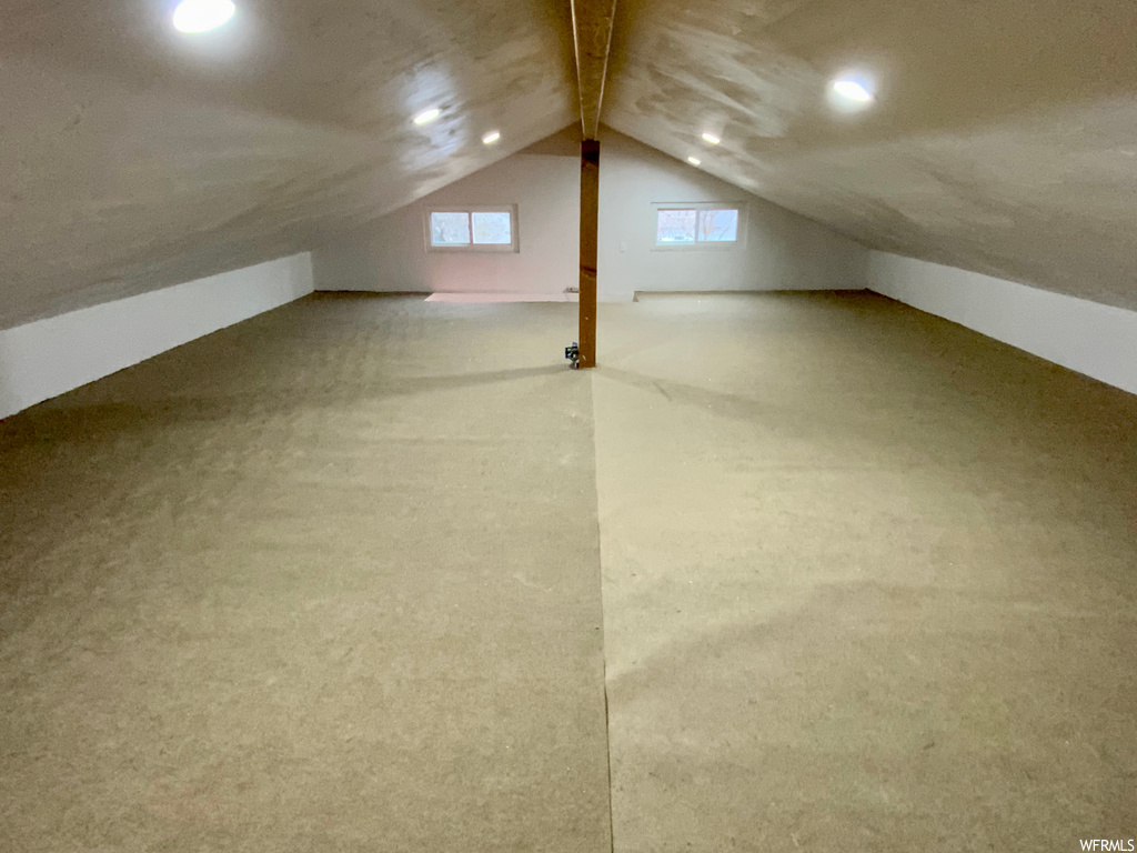 Additional living space featuring vaulted ceiling and carpet