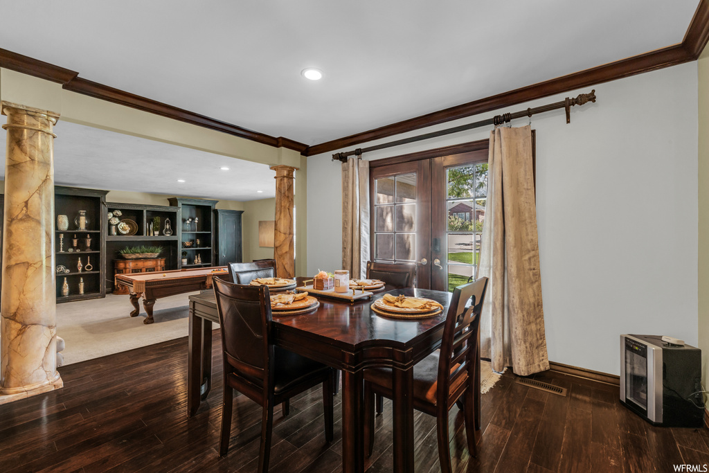 Hardwood floored dining space featuring crown molding