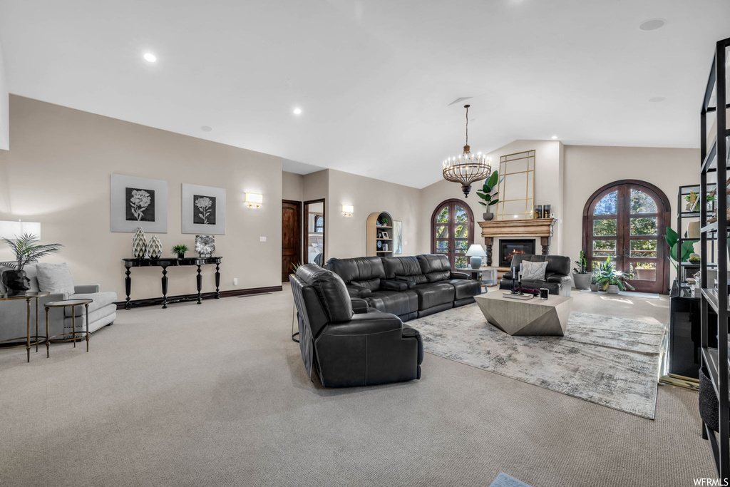 Living room featuring light carpet, vaulted ceiling, a high ceiling, and a fireplace
