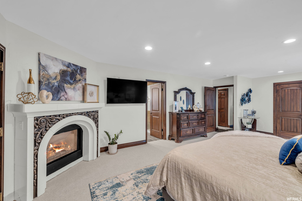 Carpeted bedroom featuring a fireplace