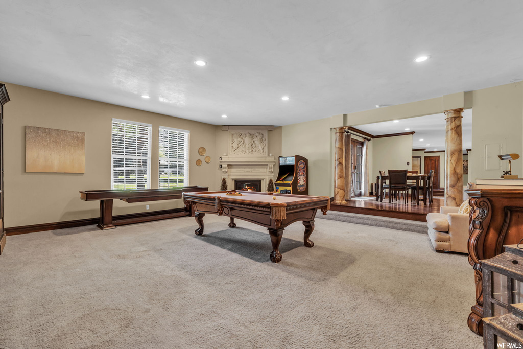 Recreation room with a fireplace and light carpet