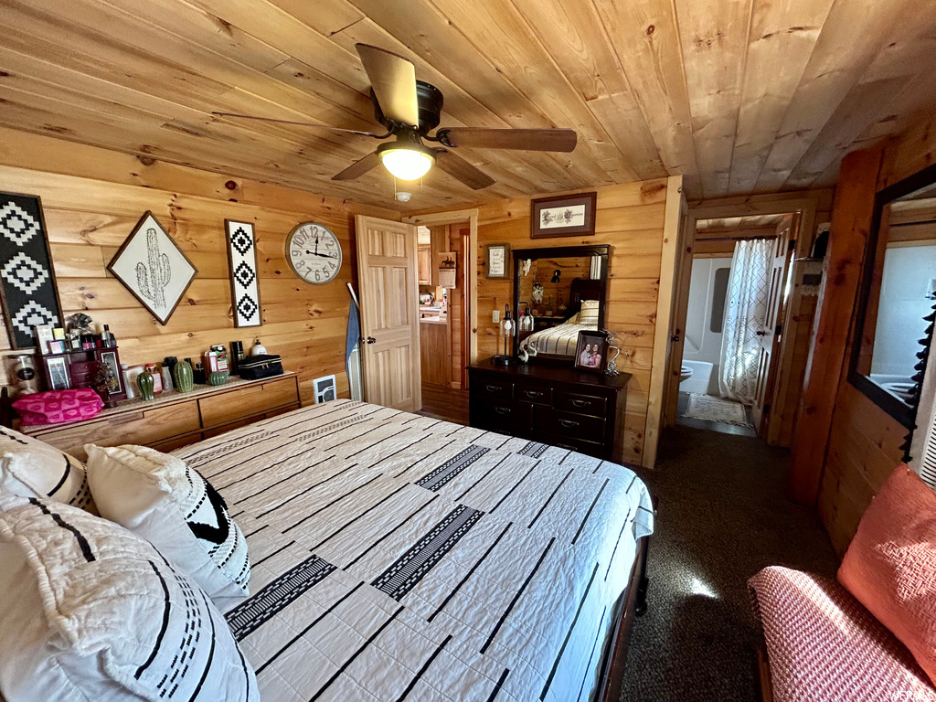 Bedroom with wood walls, wood ceiling, and ceiling fan