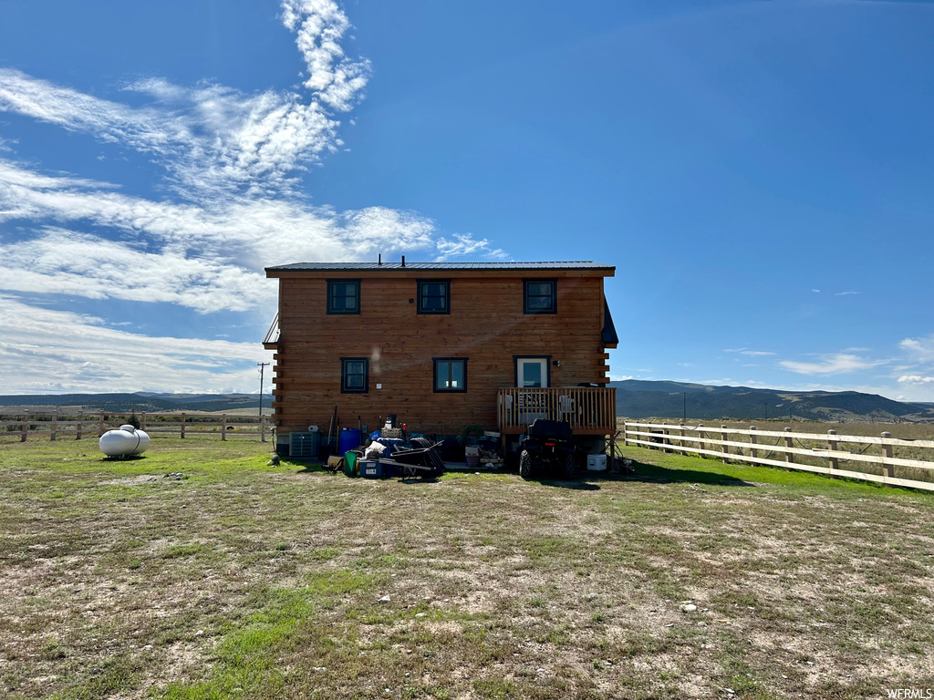 Back of property featuring a mountain view and central air condition unit