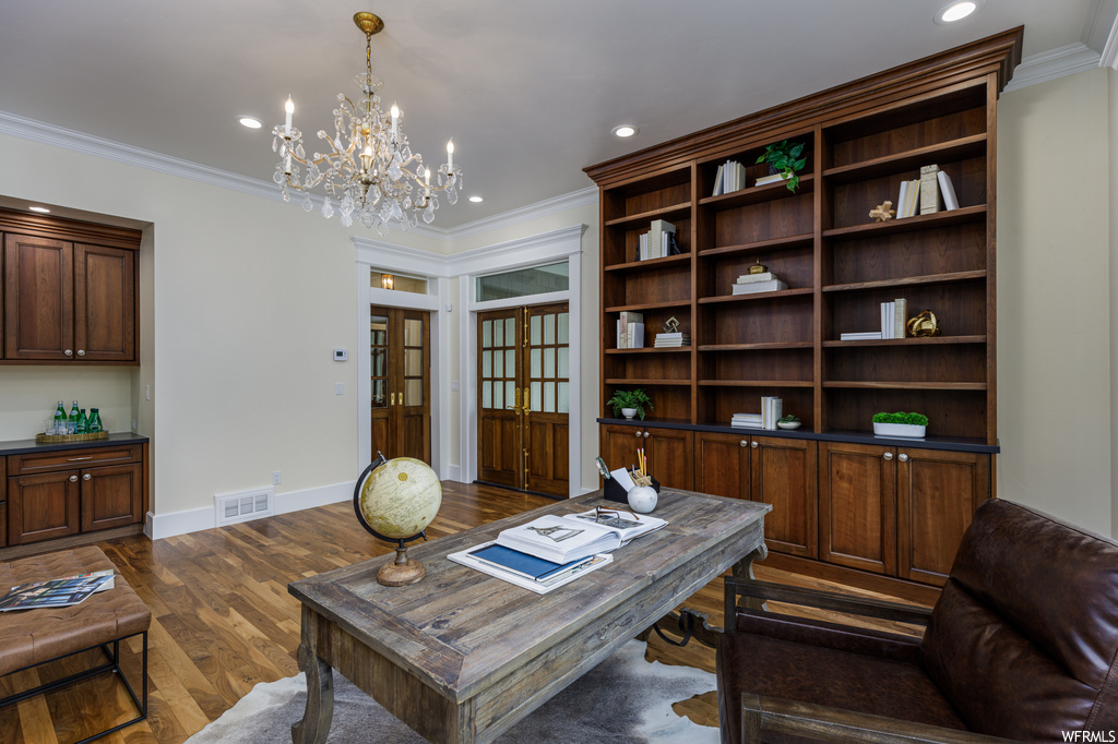Office space featuring a chandelier, crown molding, and dark hardwood flooring