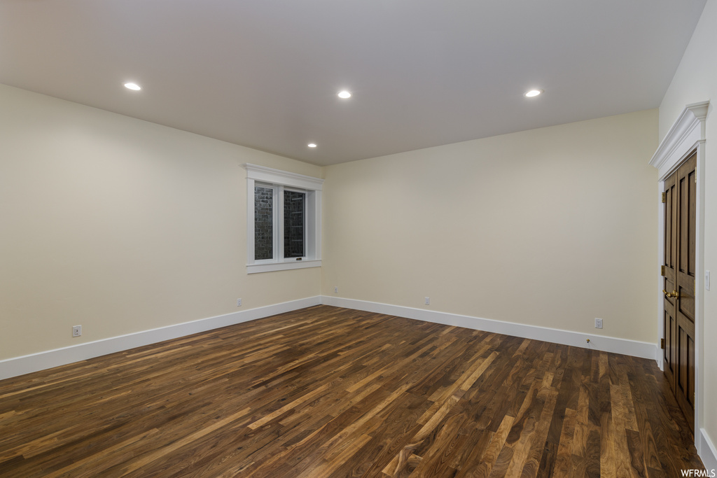 Spare room featuring dark hardwood flooring