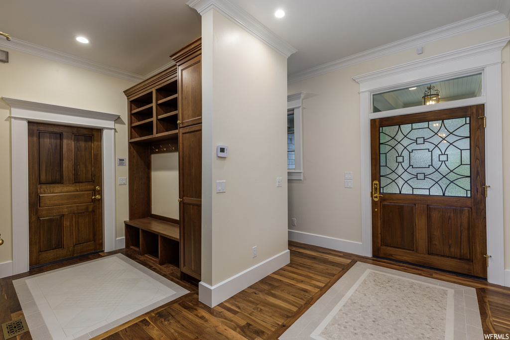Hardwood floored foyer featuring crown molding