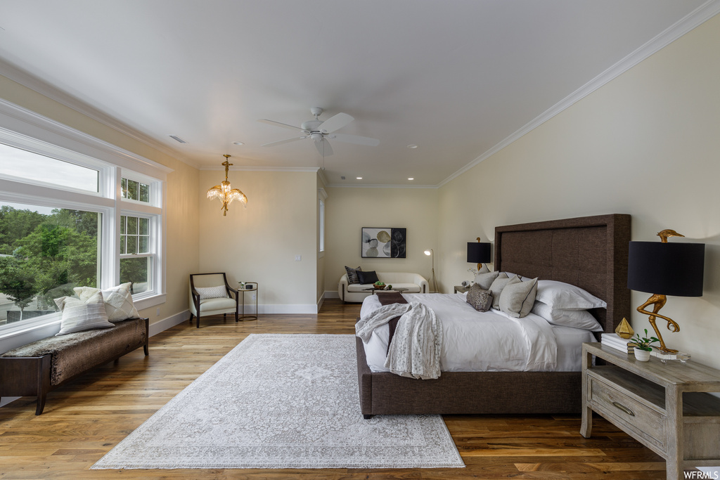 Bedroom with ornamental molding, light hardwood floors, and ceiling fan