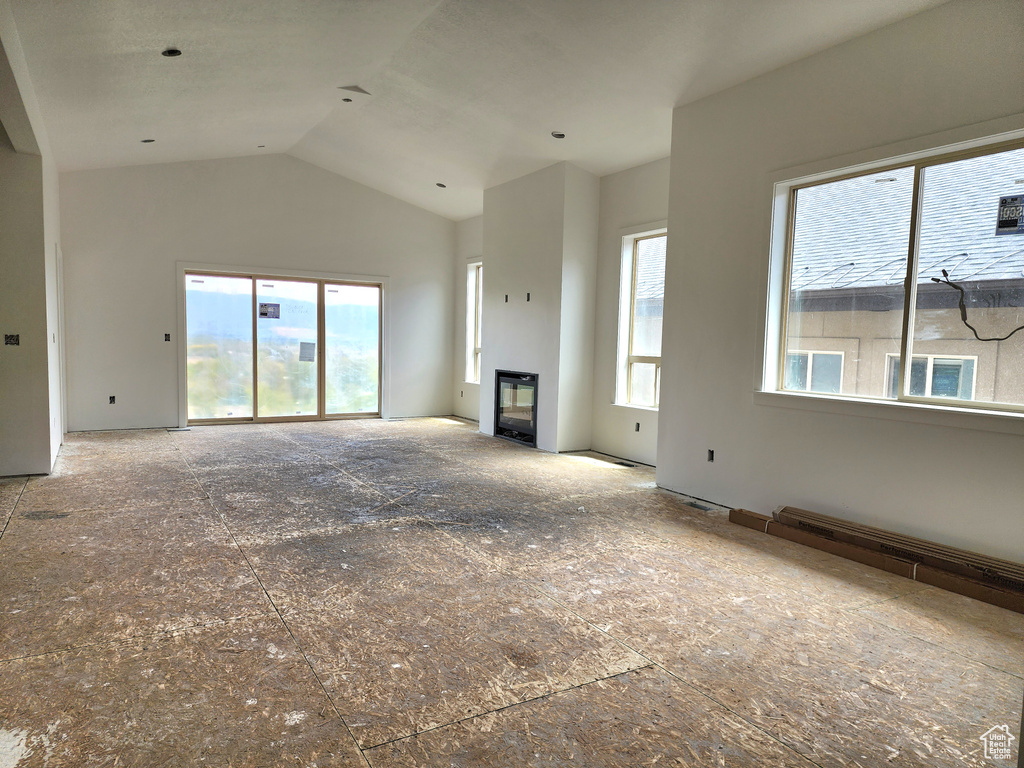 Unfurnished living room featuring vaulted ceiling