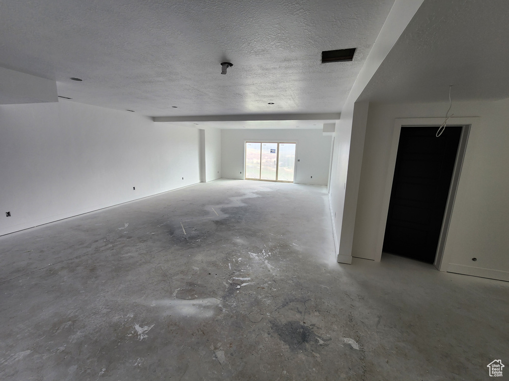 Spare room with concrete flooring and a textured ceiling