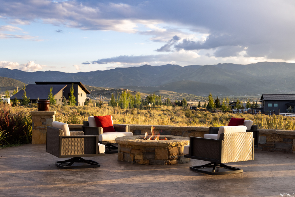 View of patio with a mountain view and a firepit