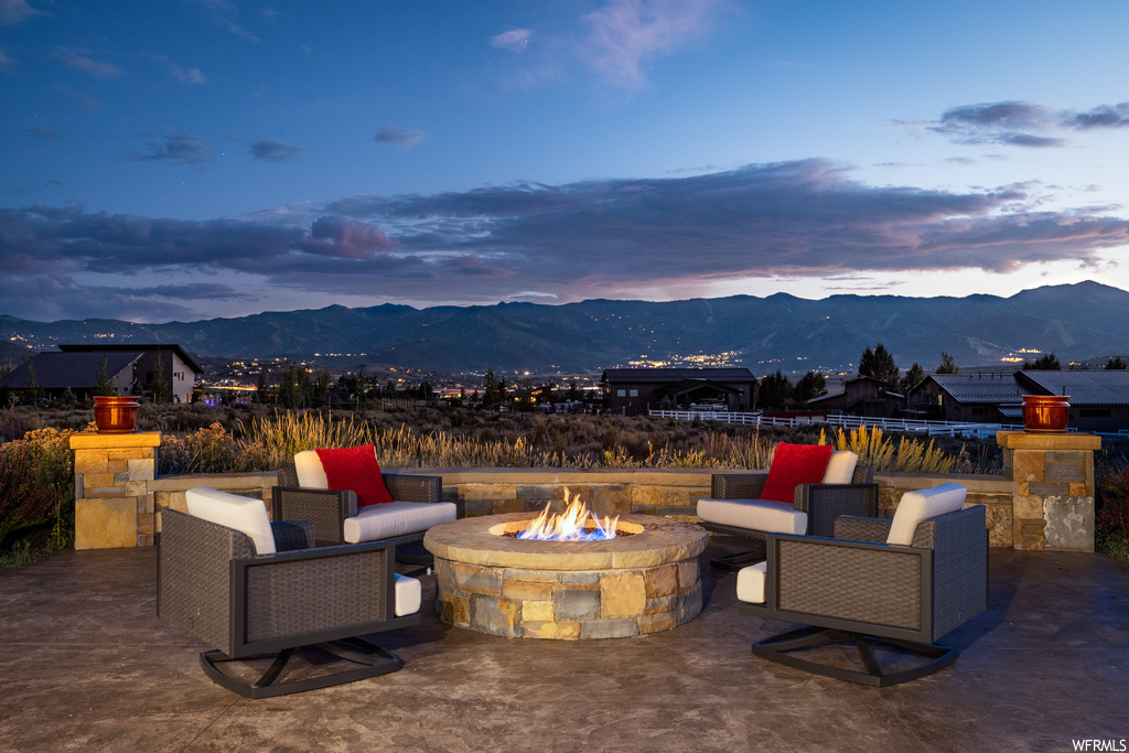 Patio terrace at dusk with a mountain view and a firepit
