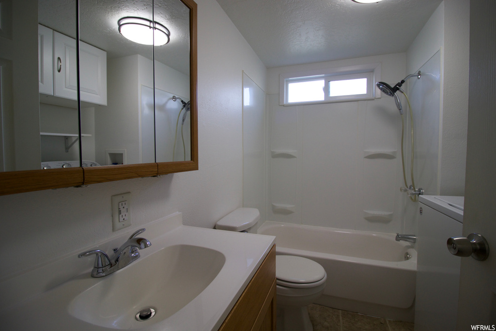 Full bathroom with a textured ceiling, mirror, vanity, tile floors, and shower / bathing tub combination