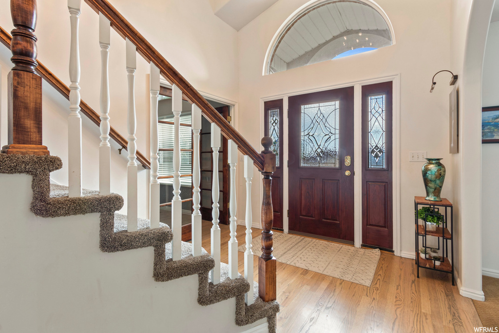 Foyer entrance featuring light hardwood floors and a high ceiling