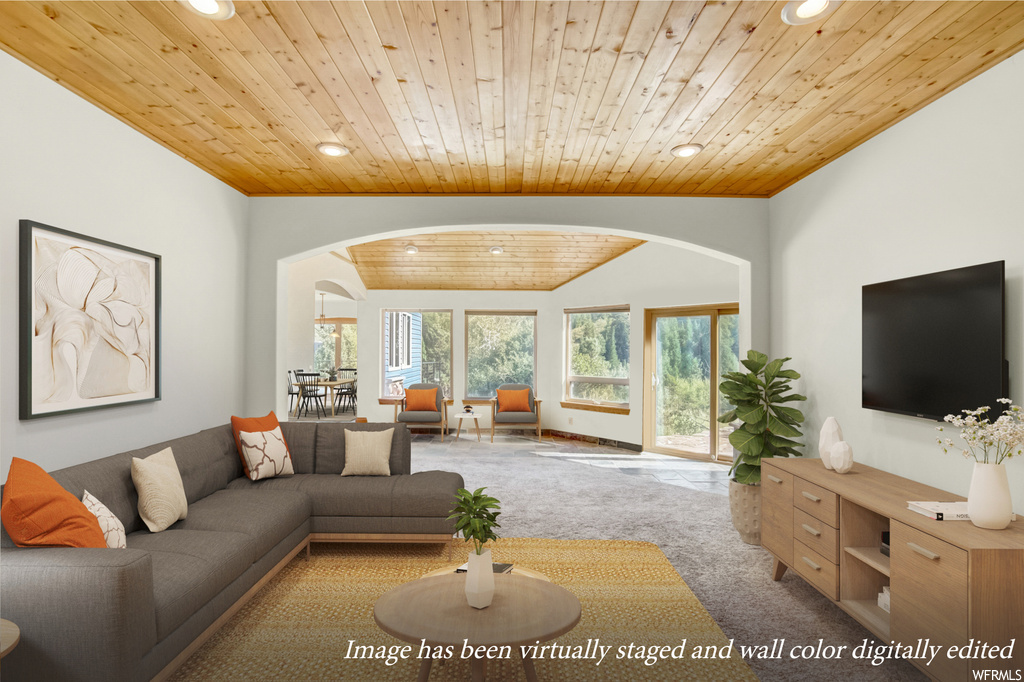 Carpeted living room with wood ceiling