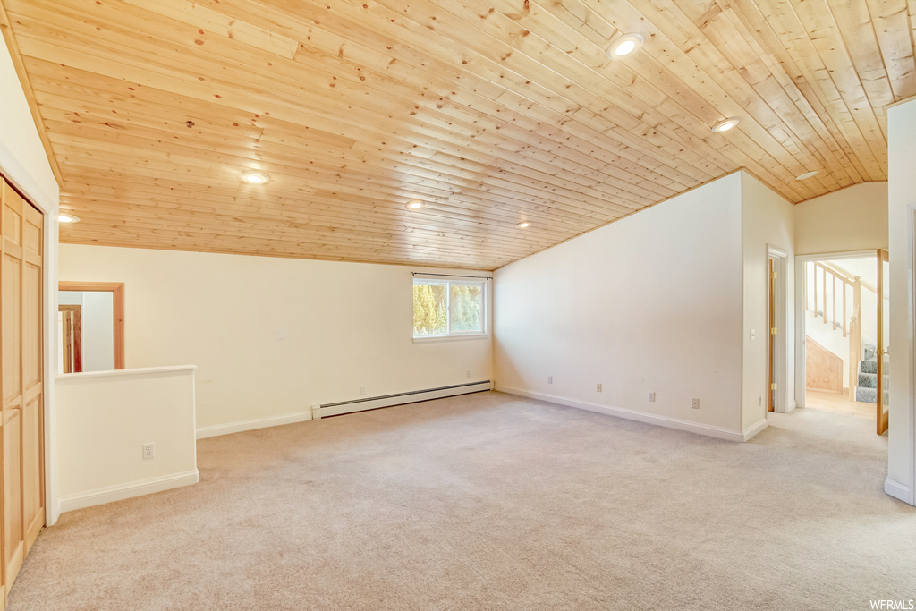 Unfurnished room with a baseboard heating unit, light carpet, lofted ceiling, and wooden ceiling