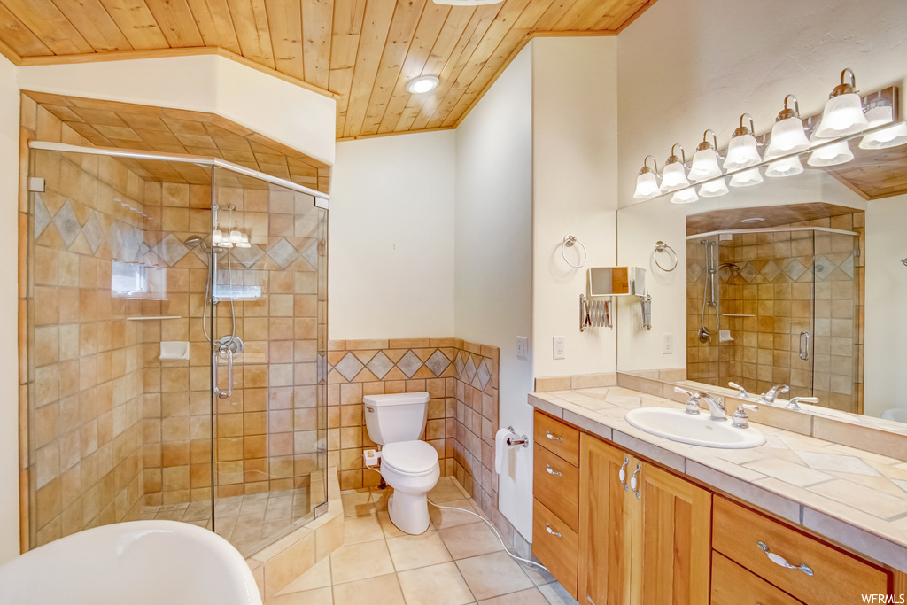 Bathroom with vanity, mirror, a shower with shower door, lofted ceiling, wood ceiling, tile walls, and light tile floors