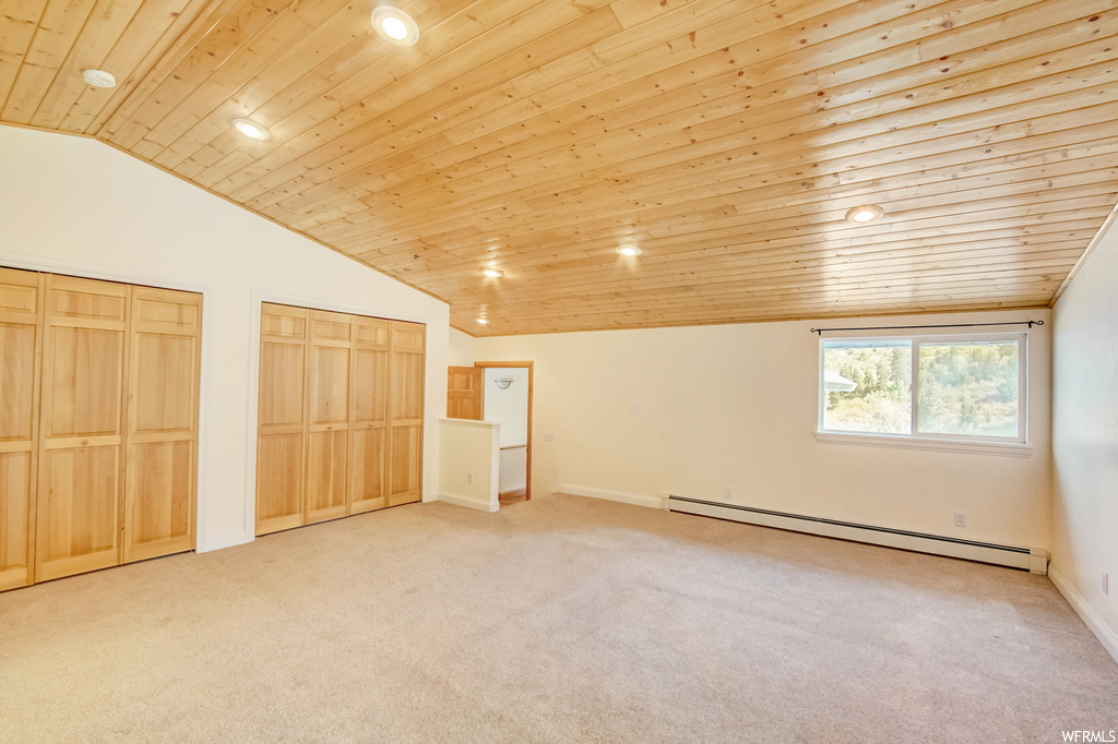Bedroom featuring baseboard heating, light carpet, lofted ceiling, and wooden ceiling