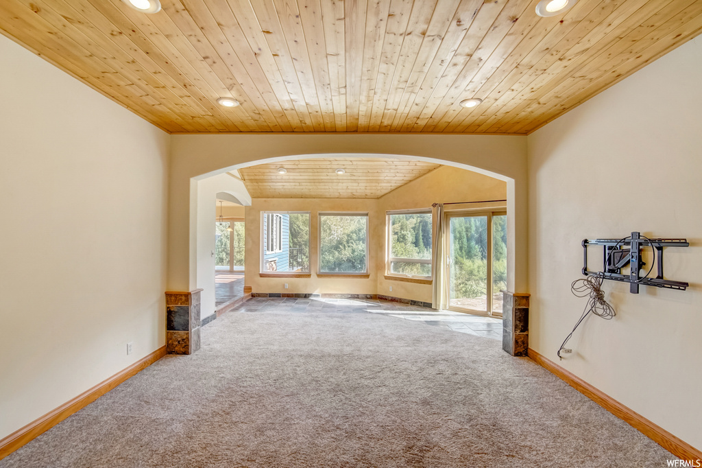 Unfurnished room with light carpet and wooden ceiling