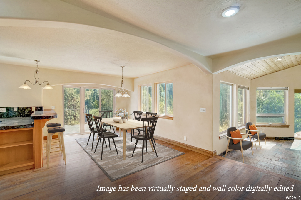 Dining space featuring a wealth of natural light, hardwood / wood-style flooring, and an inviting chandelier
