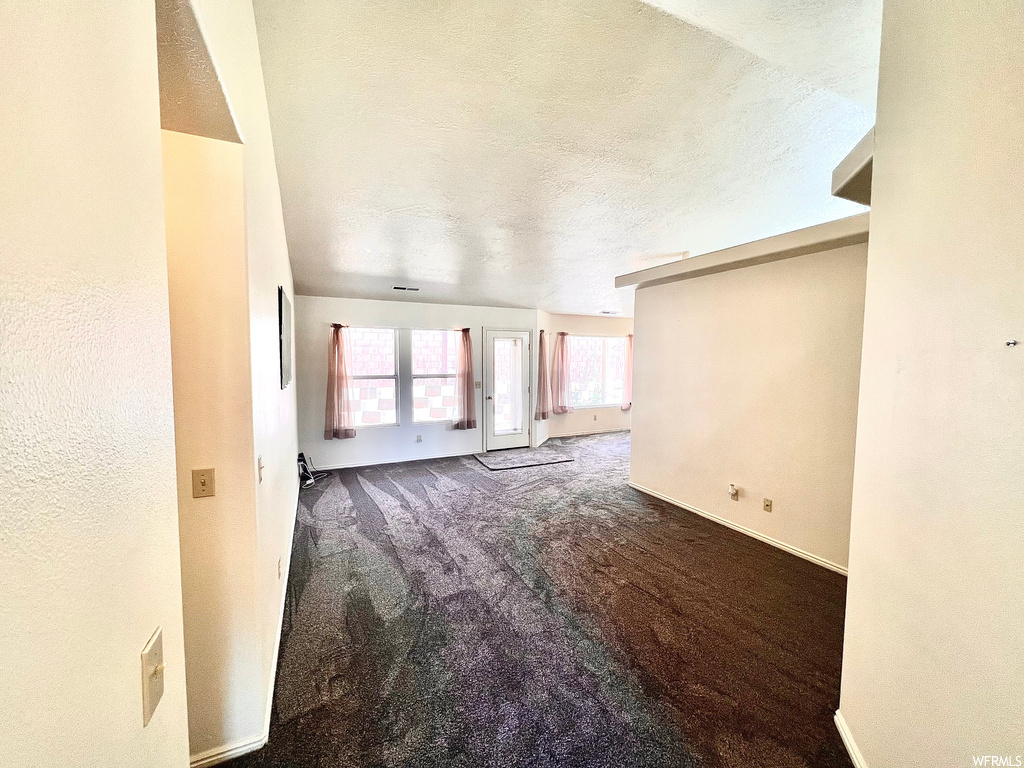 Spare room with a textured ceiling and carpet