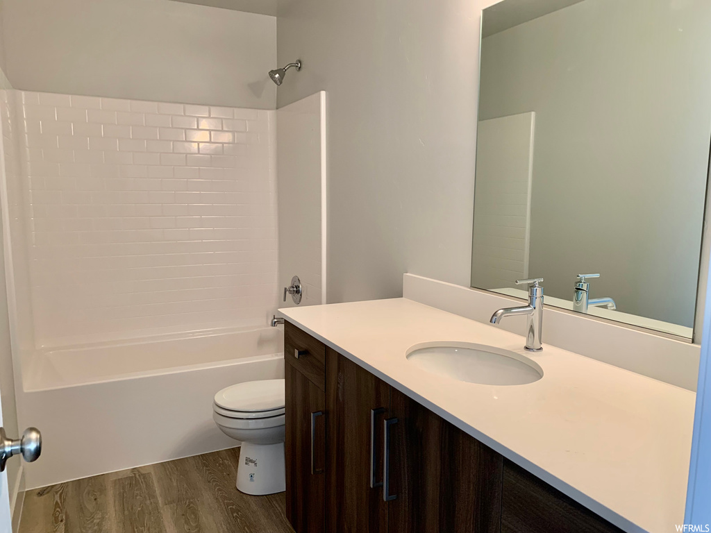 Full bathroom featuring hardwood floors, tub / shower combination, mirror, and large vanity