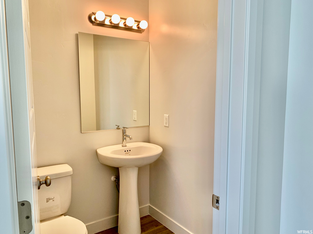 Bathroom with wood-type flooring, mirror, and washbasin