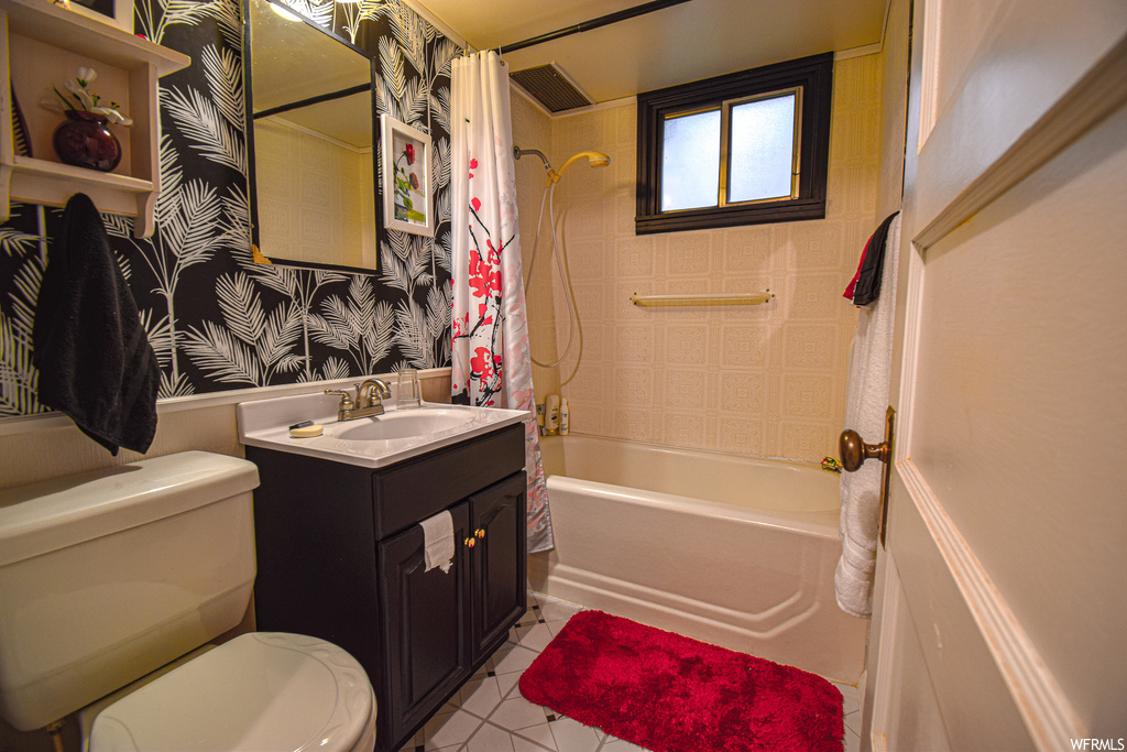 Full bathroom with tile flooring, toilet, oversized vanity, and shower / bath combination with curtain