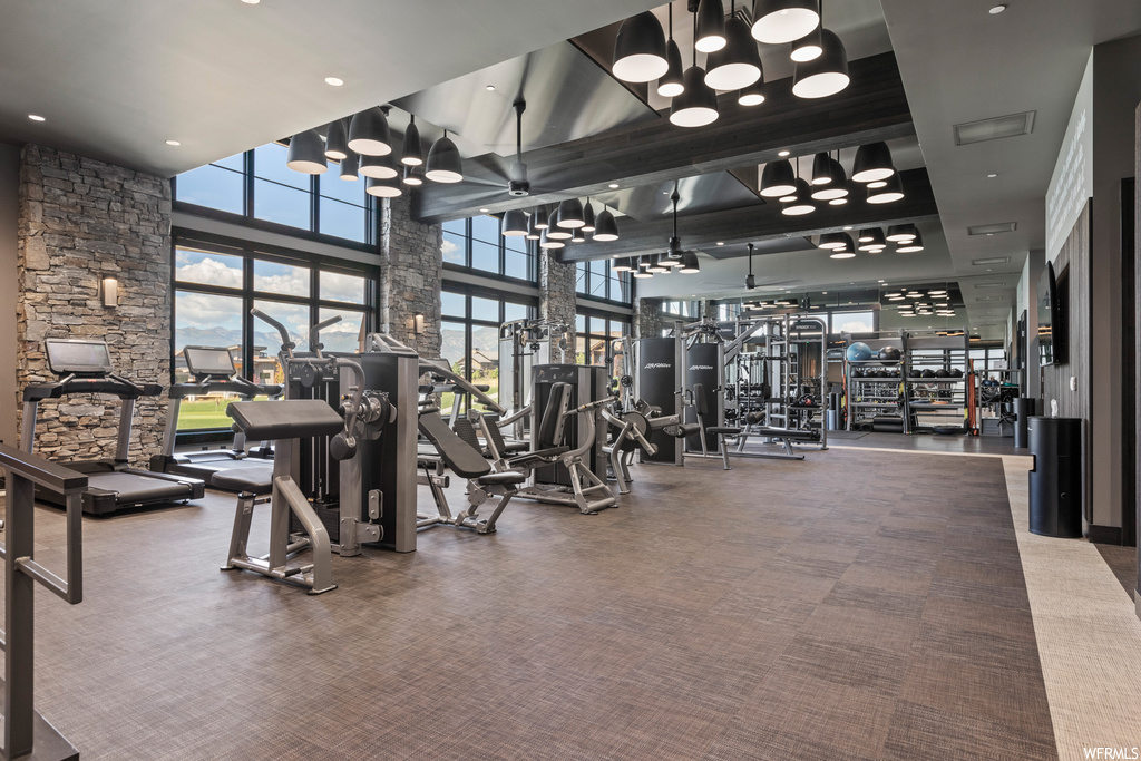 Workout area featuring light carpet and a high ceiling