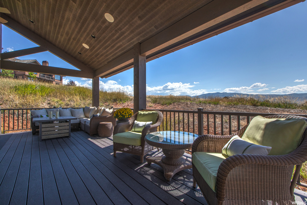Deck featuring a mountain view and an outdoor living space