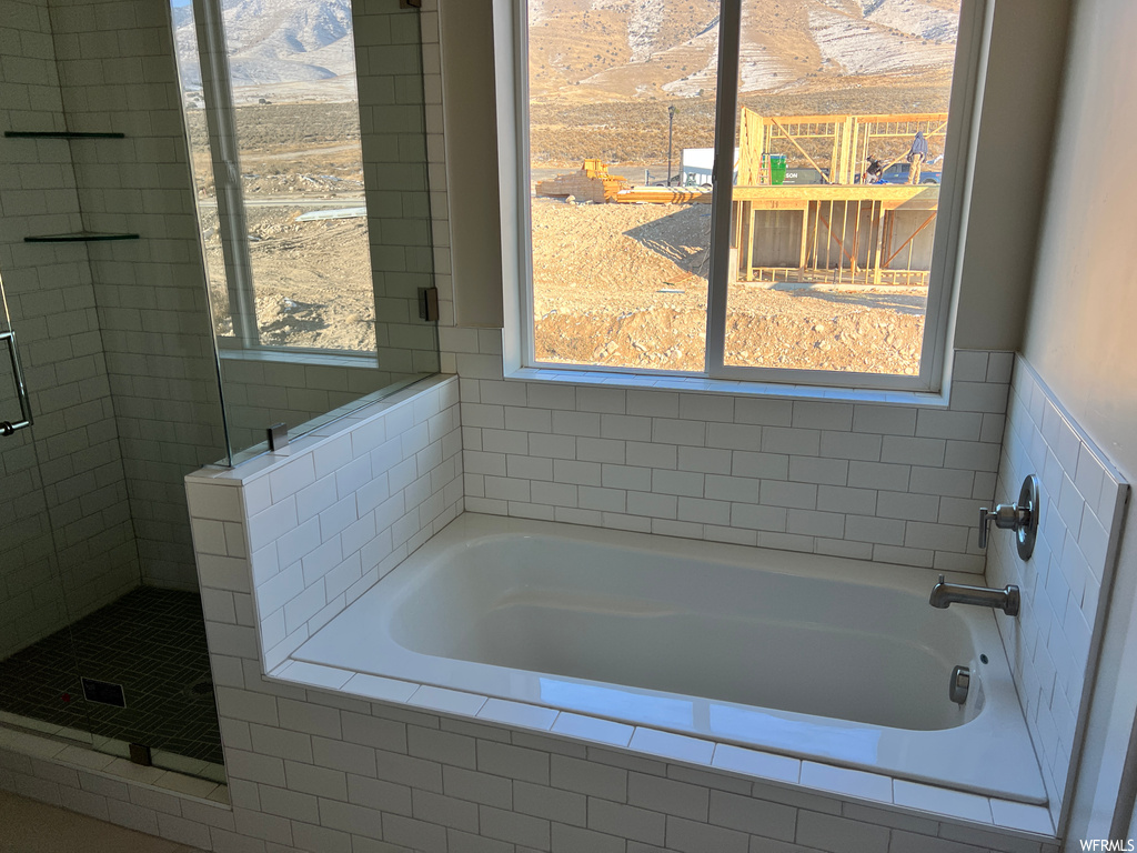 Bathroom featuring plus walk in shower, a wealth of natural light, and a mountain view