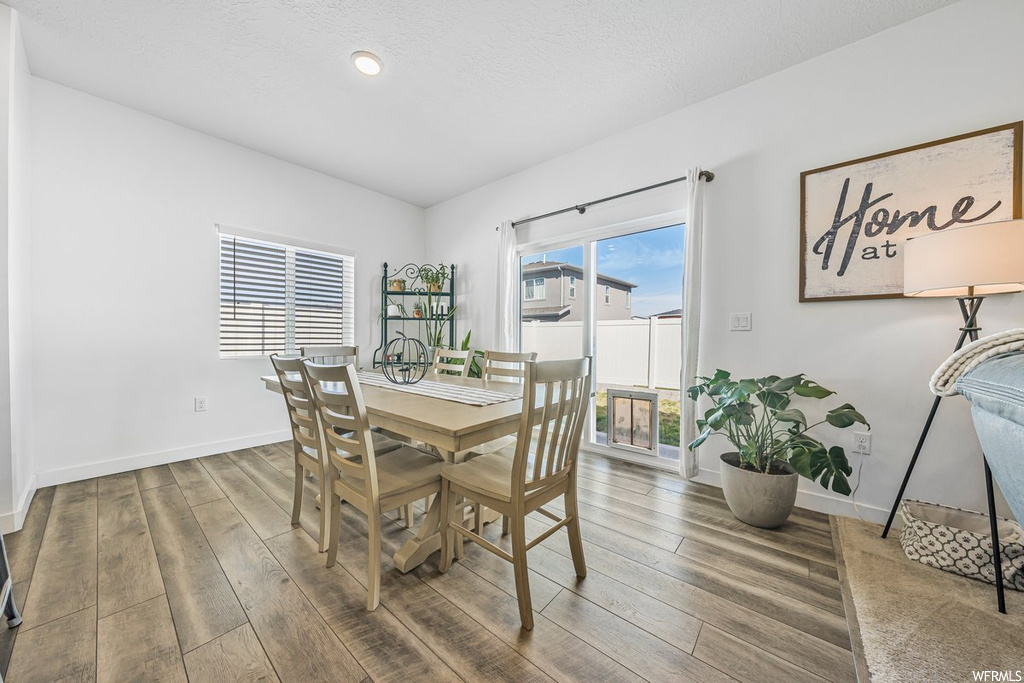 Dining space with separate washer and dryer and light hardwood flooring