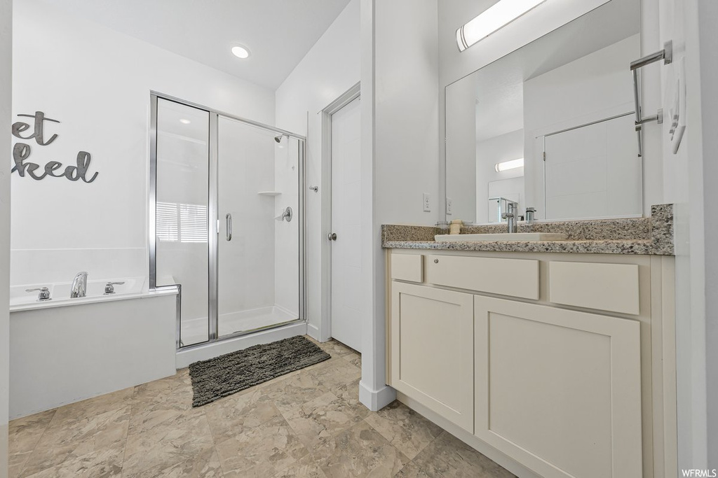 Bathroom with separate shower and tub, vanity, mirror, and light tile floors
