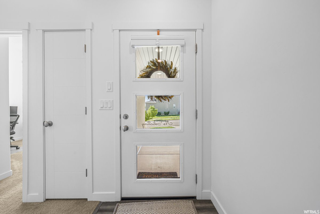 Doorway featuring light carpet